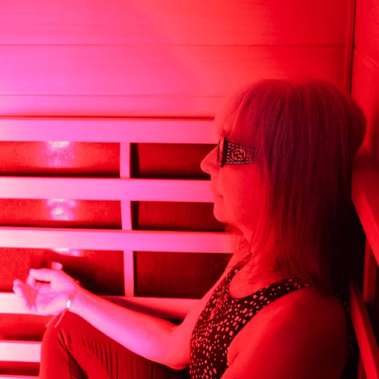 Woman relaxing in red light therapy booth
